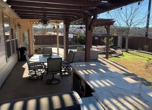 A covered patio with a table and chairs, a grill, and a view of a backyard. - Luxury Pool Oasis  2 primary suites/5 rooms/10 beds. Perfect for multi families (San Antonio)