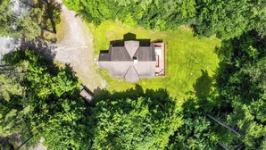 Ein Haus mit schrägem Dach, umgeben von üppigen, grünen Bäumen.