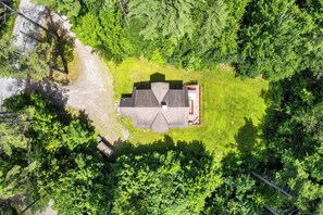 Ein Haus mit schrägem Dach, umgeben von üppigen, grünen Bäumen.