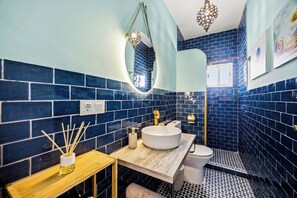 A bathroom with a round sink, a toilet, and a shower area. - Charming Apartment in Vejer de la Frontera (Vejer de la Frontera)