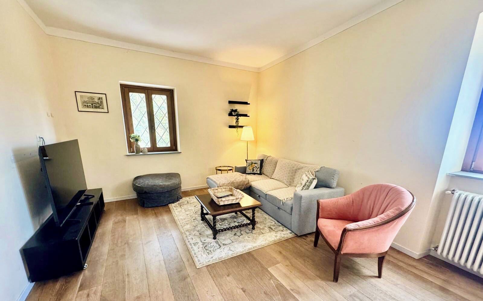 Ein Wohnzimmer mit einer Couch, einem Sessel, einem Couchtisch und einem Fernsehschrank.