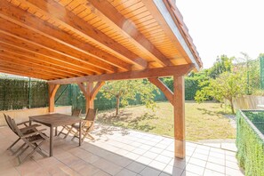 An outdoor patio with a wooden pergola, a table, and chairs. - Zeharbide - baskeyrentals (Erribera)