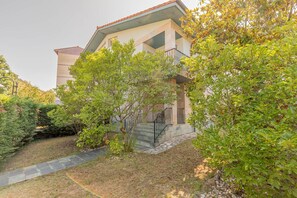 A building with a stone staircase leading to a balcony, surrounded by lush greenery. - Zeharbide - baskeyrentals (Erribera)
