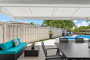 An outdoor patio with a covered seating area, a pool, and a view of the surrounding landscape. - Intracoastal Waterfront Villa w/ Private Pool (Pompano Beach)