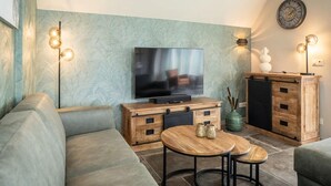 Un soggiorno moderno con una televisione a schermo piatto, mobili in legno e illuminazione decorativa.