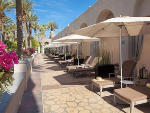 A row of sun loungers with umbrellas, palm trees, and potted plants along a walkway. - 2 Bedroom Villa at Westin Mission Hills Resort (Rancho Mirage)