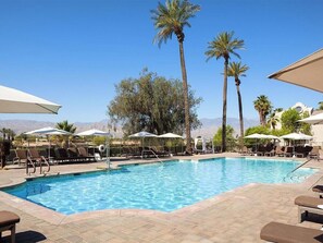 A swimming pool with lounge chairs and umbrellas, surrounded by palm trees and a mountainous backdrop. - 2 Bedroom Villa at Westin Mission Hills Resort (Rancho Mirage)