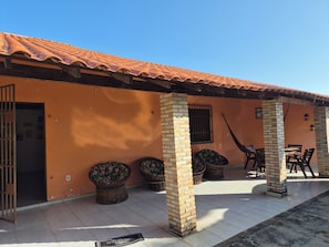 A building with a tiled roof, brick columns, and outdoor seating. - 2-bedroom and 4-suits house in beautiful Luís Correia with cool ocean breeze (Luís Correia)