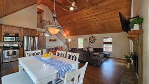 A spacious living area with a dining table, seating, and a kitchen with appliances. - Welcoming The Sinclair Hideaway (Sparta)