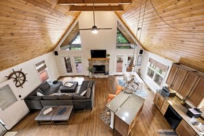 A spacious loft-style living area with a fireplace, seating, and a kitchen area. - Welcoming The Sinclair Hideaway (Sparta)