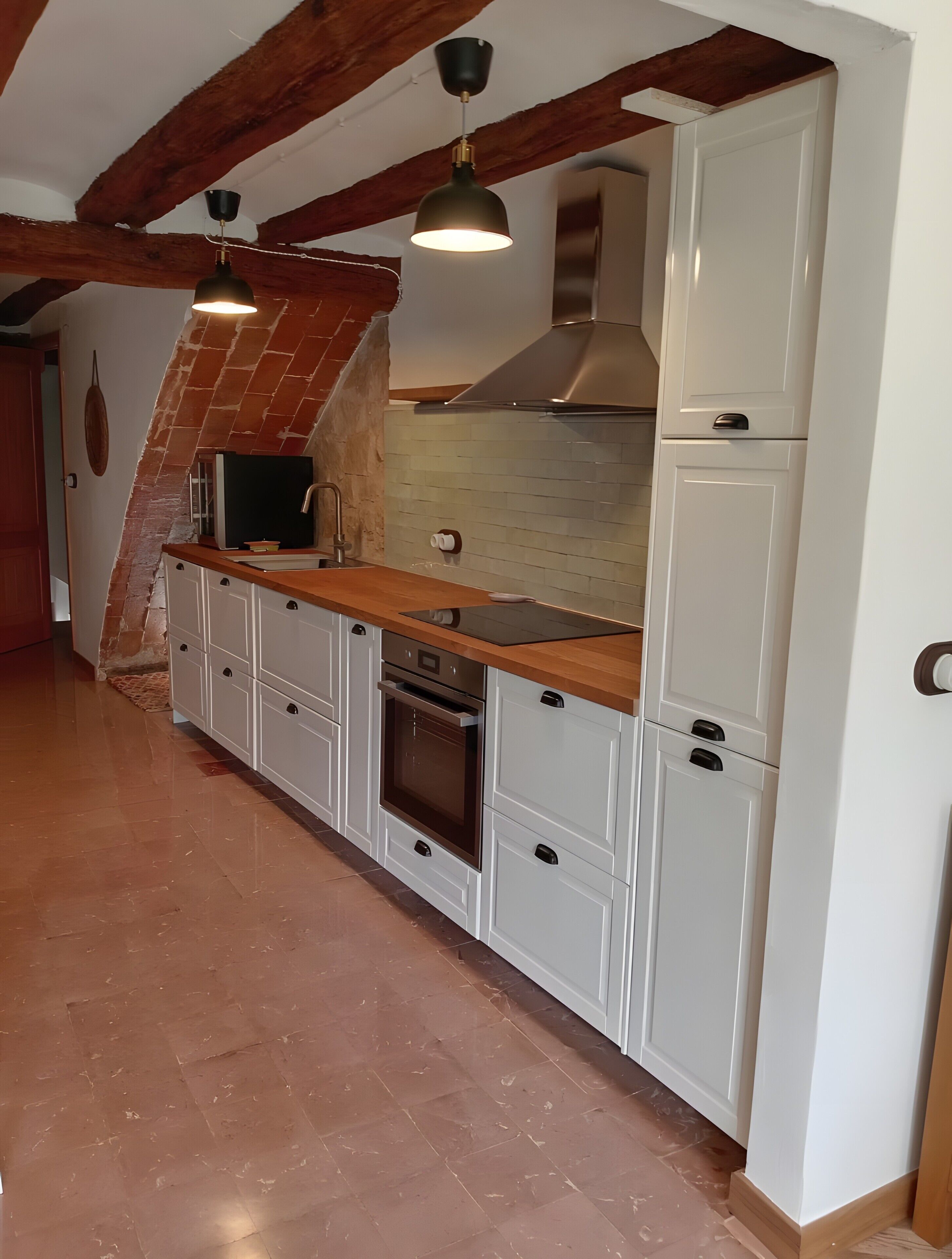 Een koffiezetapparaat/waterkoker, een koelkast, een oven, een kookplaat