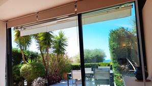 Una sala de estar moderna con un ventanal corredero que da a un patio exterior.