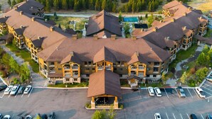 Un hotel de varios pisos con un patio central, piscina al aire libre y estacionamiento.