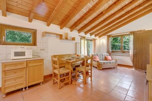 A cozy kitchen with wooden cabinets, a dining table, and a built-in microwave.