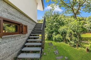 A staircase leading to a building with a stone facade and a window with wooden shutters. - Chalet La Gigliola (Laveno Mombello)