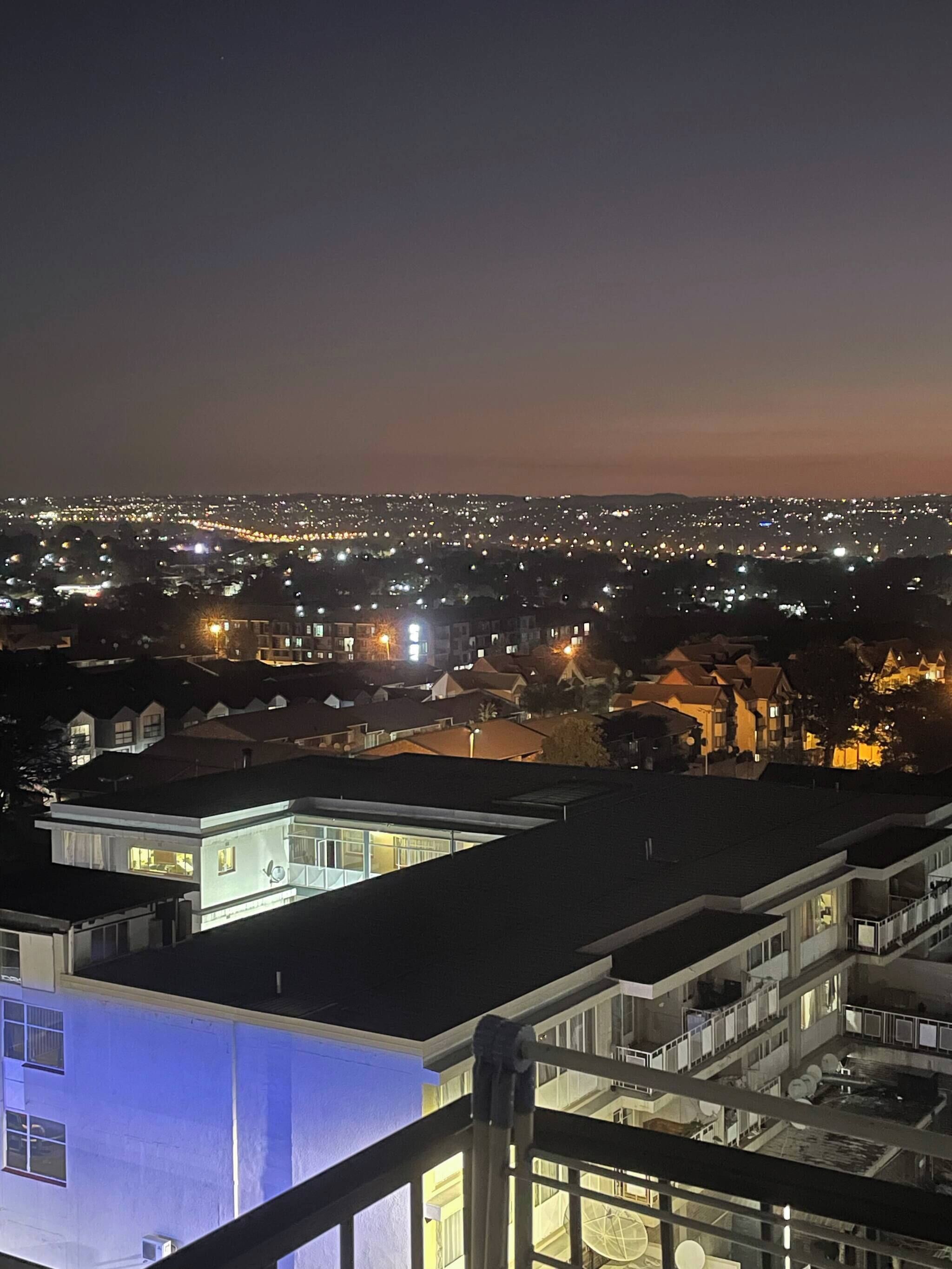 A nighttime cityscape with residential buildings and illuminated streets.