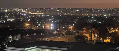 A nighttime cityscape with residential buildings and illuminated streets.