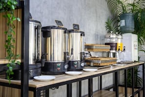 A coffee station with multiple coffee dispensers, a water dispenser, and a coffee machine.