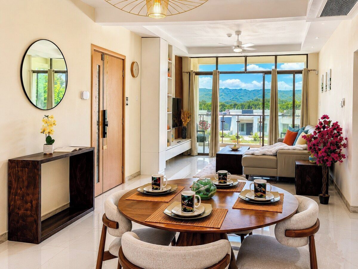 A modern living room with a dining area, a sofa, a TV, and a view of the outdoors.