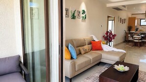 A living room with a sofa, a coffee table, and a dining area in the background. - The Azure Suite Ocho Rios | 2BR (Ocho Rios)