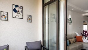 A modern living room with a glass partition, grey sofas, and abstract wall art. - The Azure Suite Ocho Rios | 2BR (Ocho Rios)