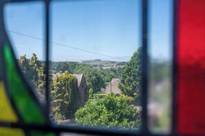 Vista a través de una ventana que muestra un paisaje rural, con casas y árboles.