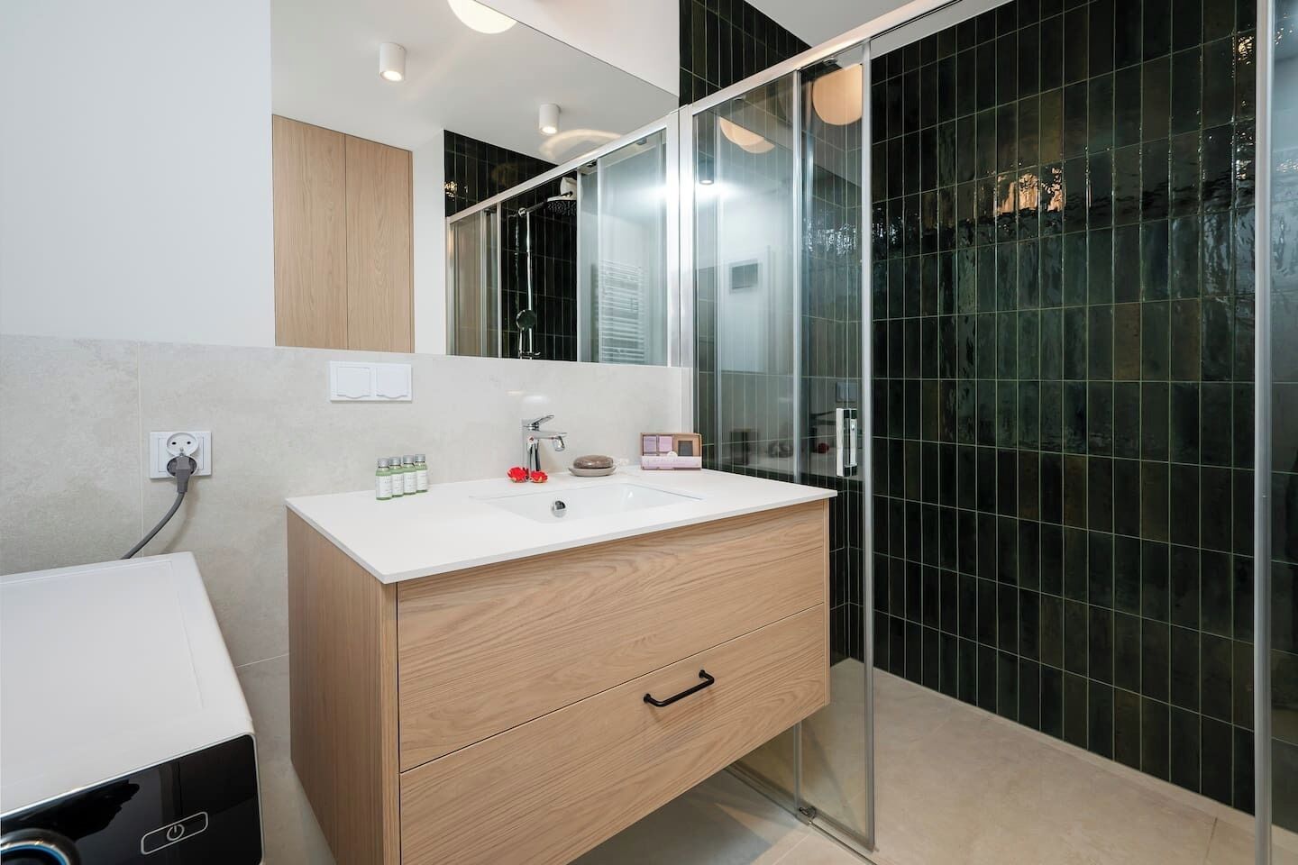 A modern bathroom with a glass shower enclosure, a wooden vanity, and a white sink.