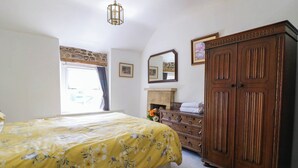 Un dormitorio con cama, cómoda, armario y espejo.