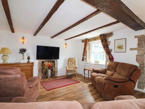 A cozy living room with a fireplace, a television, and comfortable seating.