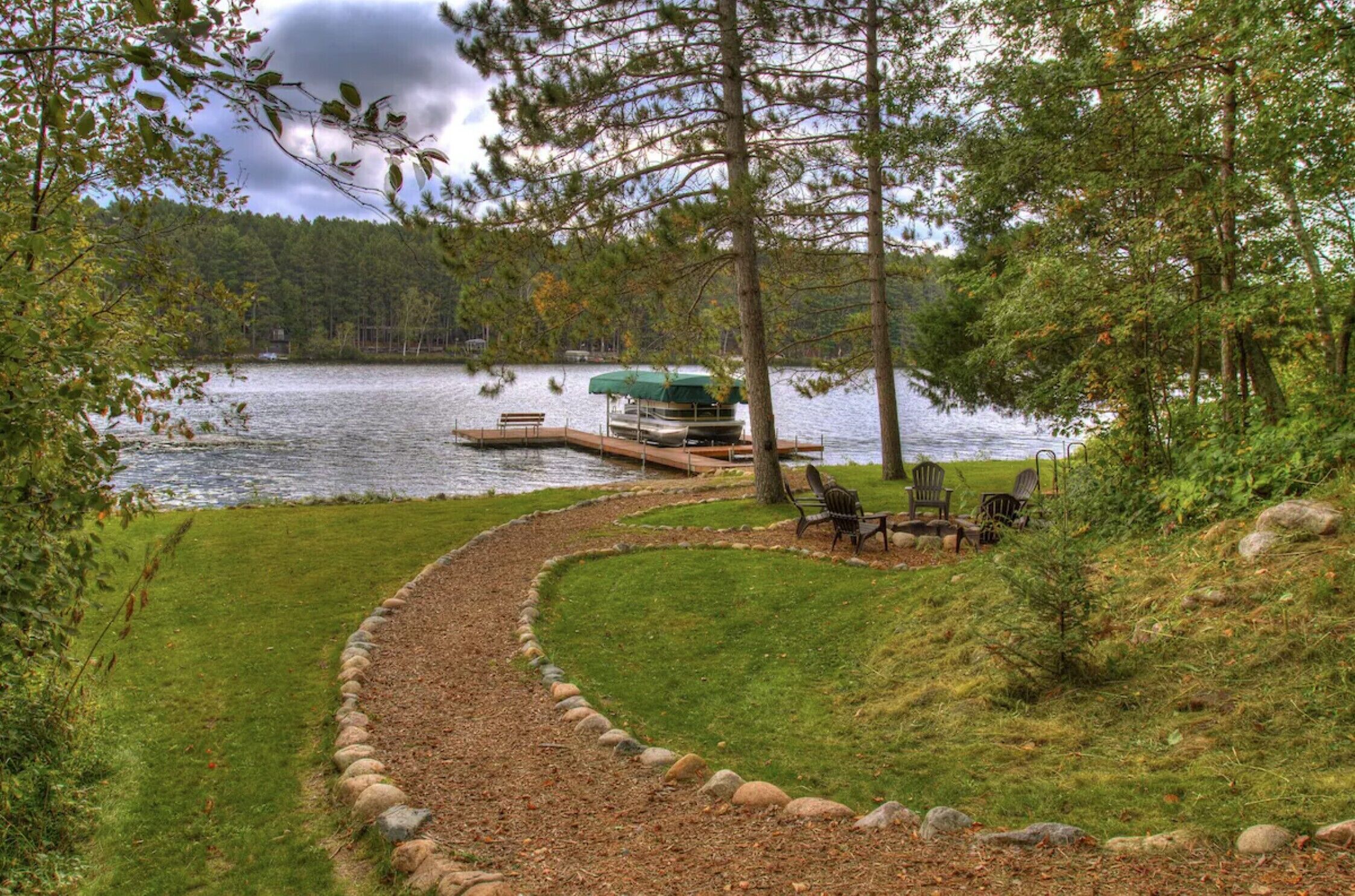 A lakeside property with a dock, a boat, and outdoor seating.