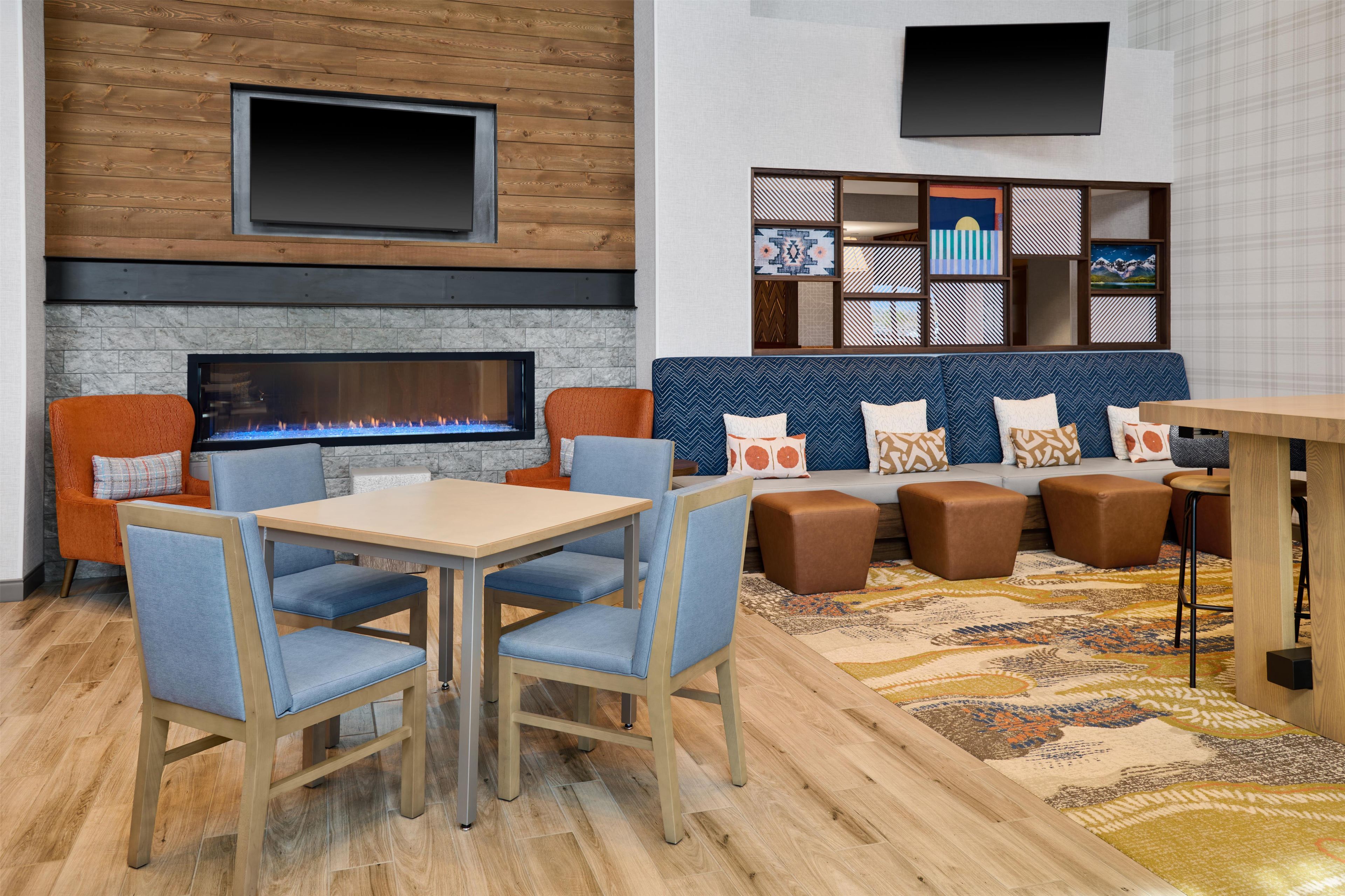 A modern lounge area with a fireplace, seating, and a flat-screen TV.