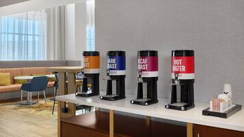 Een koffiehoek met vier koffiesoorten: een lichte branding, een donkere branding, decaf en heet water.