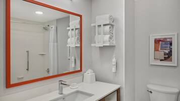 A bathroom with a large mirror, a sink, a toilet, and a towel rack.