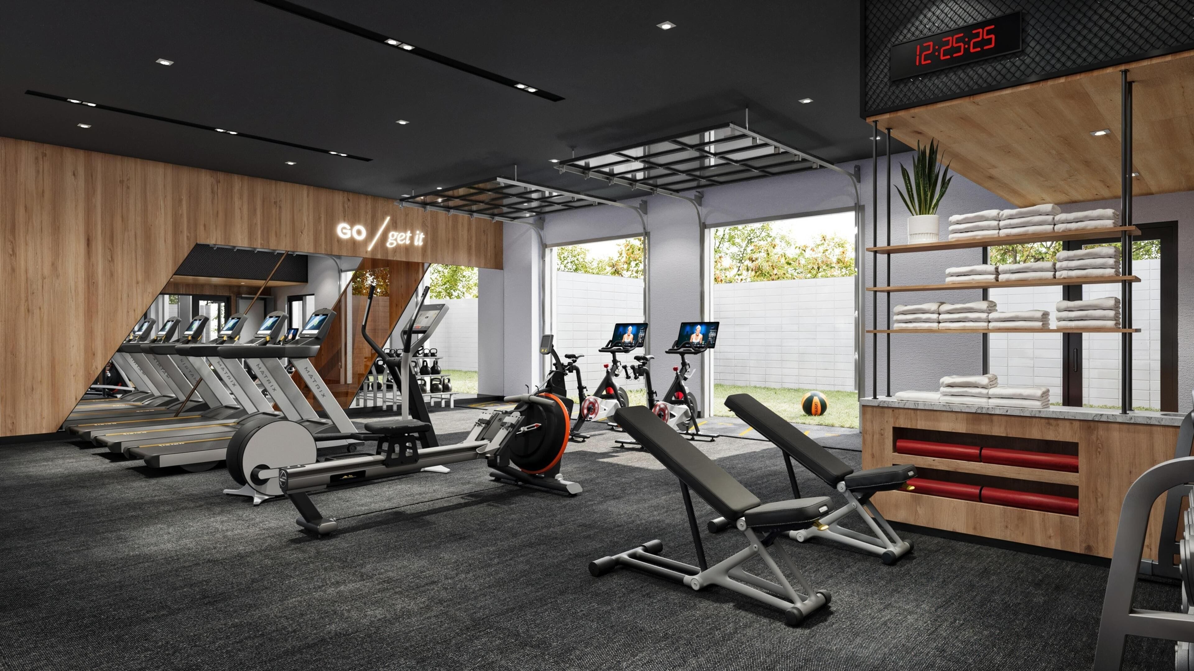 A modern gym with treadmills, stationary bikes, and a bench press area.