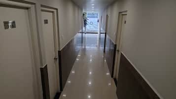 Pasillo de hotel con puertas numeradas 305 y 306, que da a un estacionamiento.