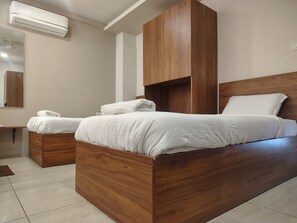 Un dormitorio moderno con estructura de cama de madera, ropa de cama blanca y cabecera de madera integrada.