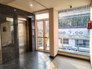 An elevator with a sign indicating the 3rd floor, a glass door entrance, and a fire extinguisher mounted on the wall. - Hotel Raayara Bliss Koramangala (Bengaluru)