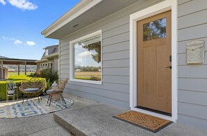 Ein Haus mit Veranda, zwei Fenstern, einer Tür und einem Briefkasten.