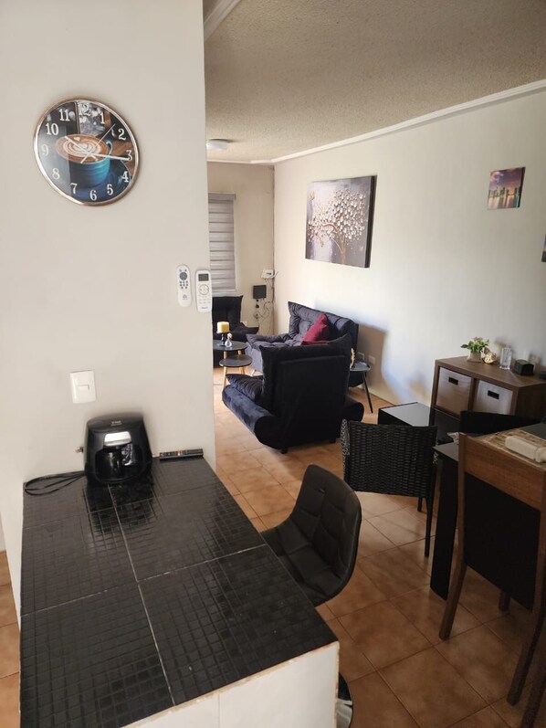 A compact living space with a kitchenette, a dining area, and a seating area.