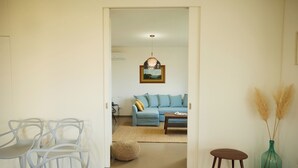 Una sala de estar con un sofá, una mesa de centro y una lámpara colgante.