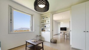 Una sala de estar moderna con un amplio ventanal, un comedor y una cocina.