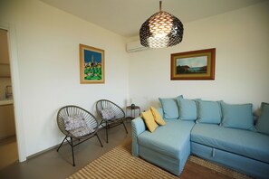 Deluxe-Villa, Buchtblick | Wohnbereich | 40-Zoll-Flachbildfernseher mit Digitalempfang, Bücher, Stereoanlage