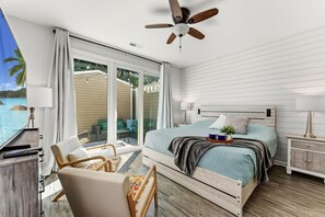 A bedroom with a bed, a chair, a nightstand, a lamp, a ceiling fan, and a view of the ocean. - Designer Family Beach House · Walk to Sand & Golf (North Myrtle beach)