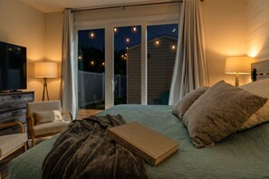 A bedroom with a bed, a chair, a book, and a TV. - Designer Family Beach House · Walk to Sand & Golf (North Myrtle beach)