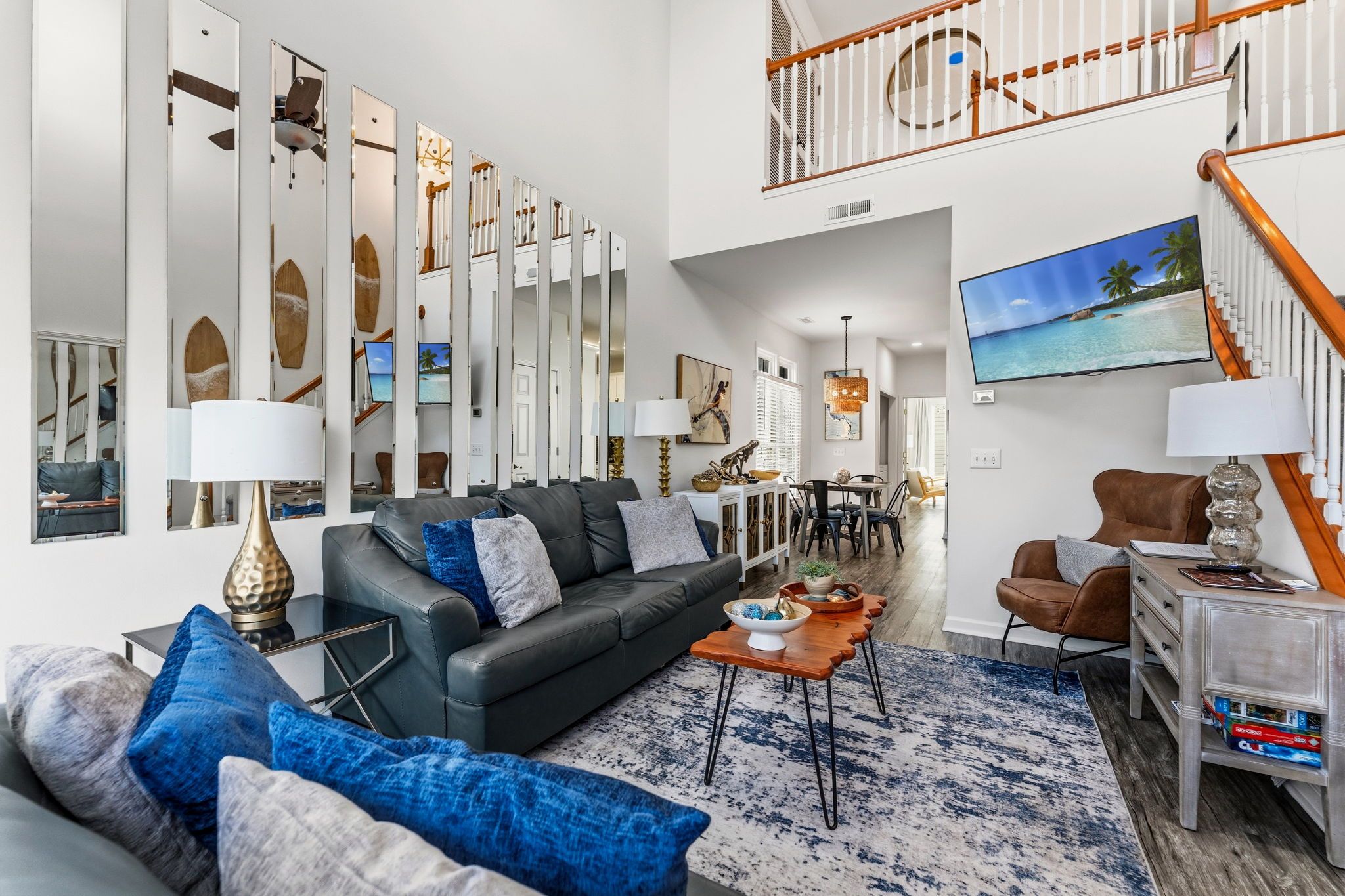 A modern living room with a sofa, coffee table, and a dining area with chairs.