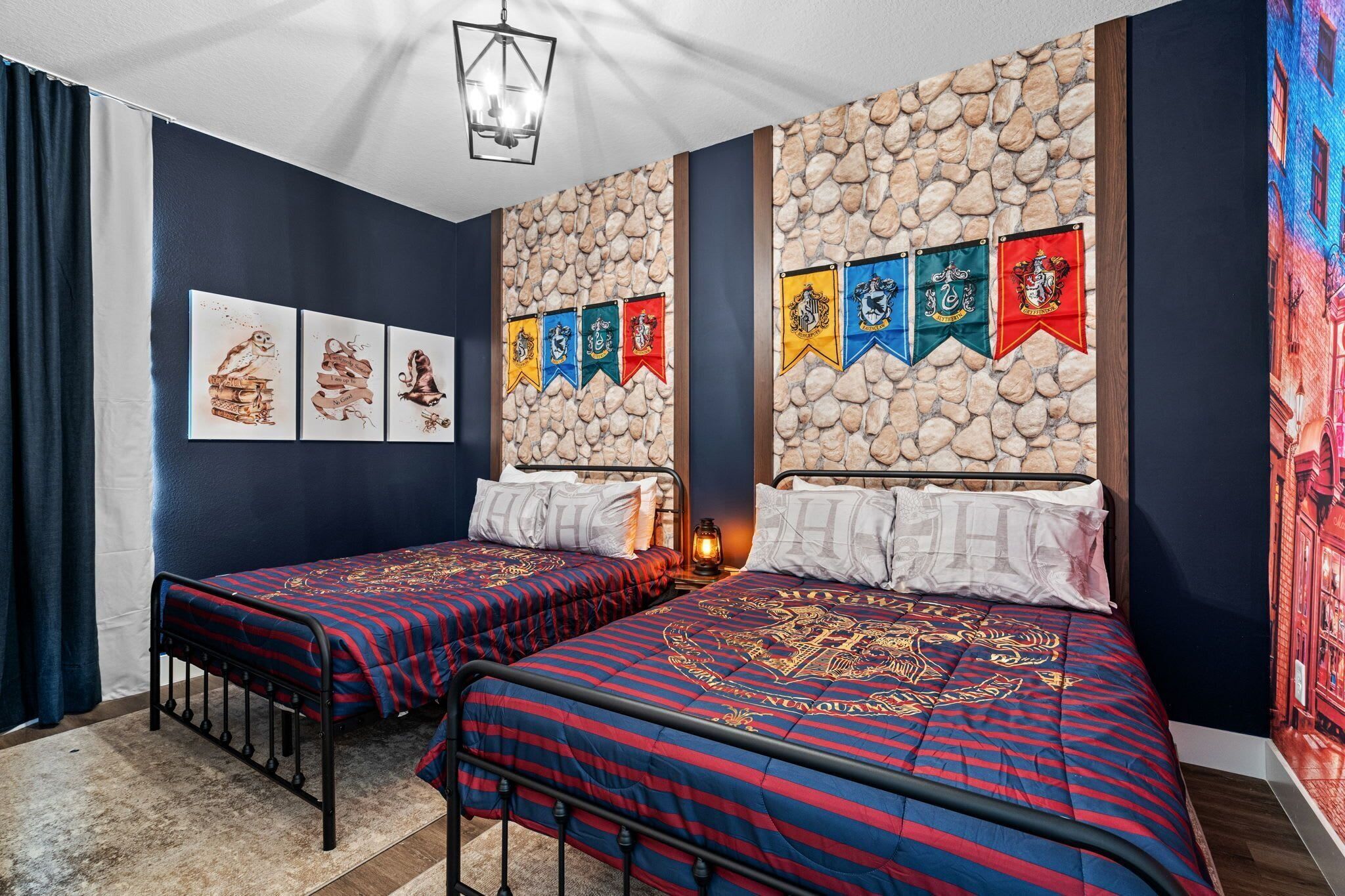 Une chambre avec deux lits, un mur en pierre et une série de drapeaux.