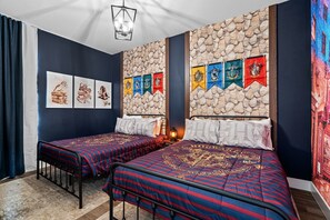 A room with two beds, a stone wall, and a series of flags. - Modern 5BR Home Near Disney With Private Pool (Davenport)