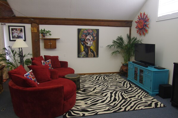 A living room with a red sofa, a zebra-patterned rug, a blue cabinet, and a television. - Unique Barn Loft.
Mexican inspired Barn Store on site, 10 acers walking trails. (Essa)