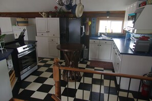 A kitchen with a checkered floor, white cabinets, a wooden table, and a hanging pot rack. - Unique Barn Loft.
Mexican inspired Barn Store on site, 10 acers walking trails. (Essa)