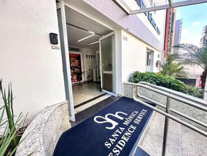 A hotel entrance with a doormat that reads 'Santa Monica Residence Service.' - Santa Mônica Residen (São Paulo)